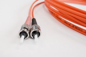 Orange fiber optic cable on a white surface