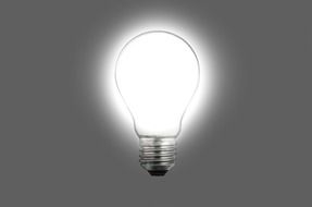 burning electro light bulb on gray background