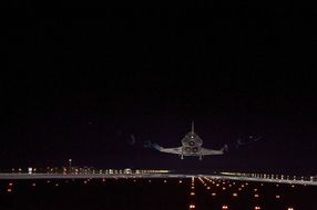 space shuttle endeavour above runway at night