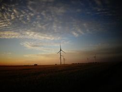 sunset in the clouds over wind turbines