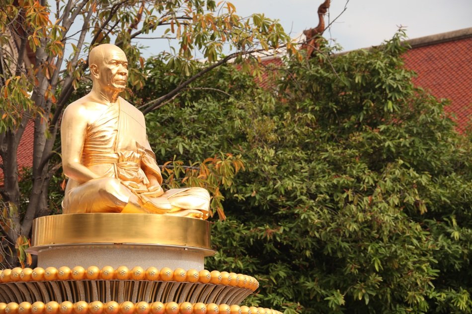 golden buddha statue near the bush