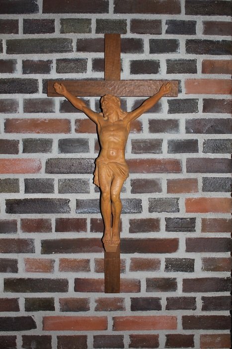 small wooden figurine in the shape of crucified Christ on the wall