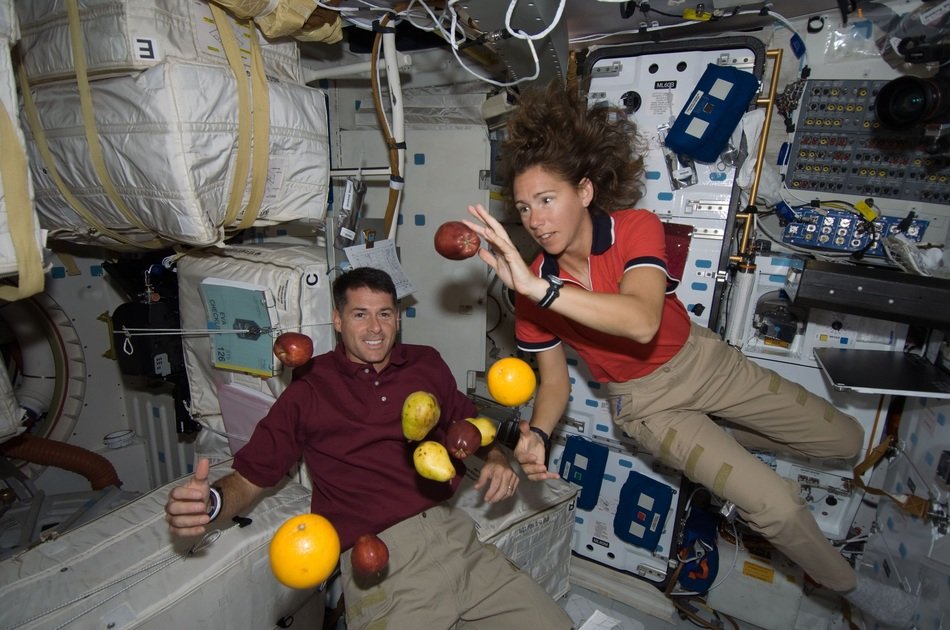 Astronauts with fruit in a state of weightlessness