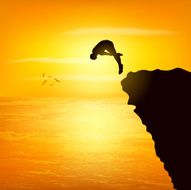 Silhoutte of a man jumping from the rock