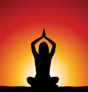 Woman perfoming yoga in front of sunrise