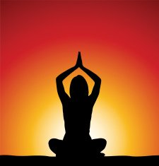 Woman perfoming yoga in front of sunrise