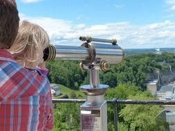 the child is looking through a telescope