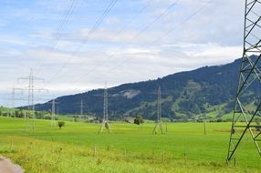 masts of power lines in a green field