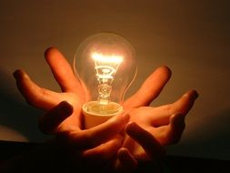 bright light bulb in hands