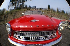 front of a red historic car