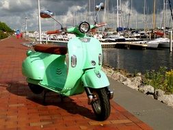 Green electric scooter on the waterfront