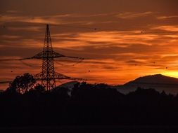 silhouette of a power line against a bright sunset