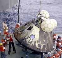 people around apollo 13 landing module at sea