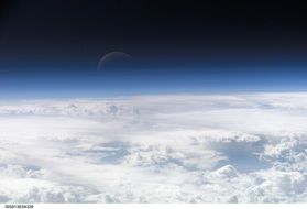 crescent moon in space above the earth