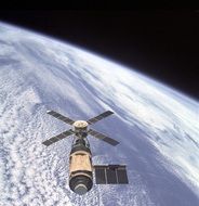 Skylab orbital workshop above the Earth at dark space background