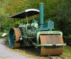 Steam roller near the green forest