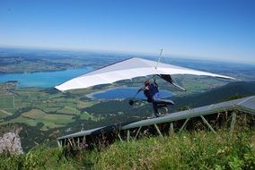 flying a hang glider over green terrain