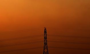 power lines and tower at orange sky
