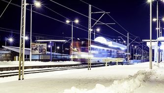 train passing by station at snowy winter night