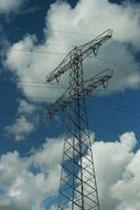 high voltage mast on the blue sky with white clouds