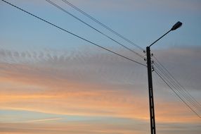 street lantern and power lines at sunset sky