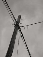 wooden pillar with electrical wiring at cloudy sky