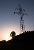 metal pole with electric wires on the hill