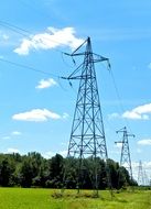 landscape of high voltage power lines with electric towers at summer