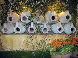 decorative jugs on the wall in the garden