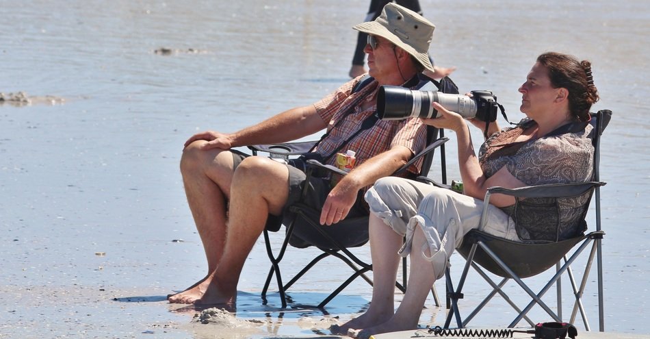 couple with camera at the beach