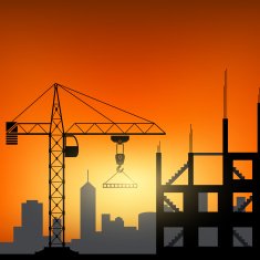 Construction cranes at sunset background