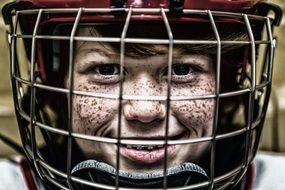 cute freckled child boy in hockey helmet, portrait