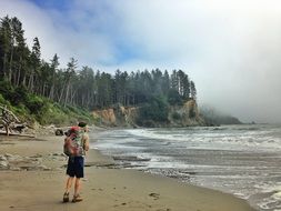 tourist with backpack in the Olympic National Park on the Pacific Ocean