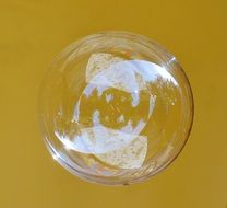 single soap bubble on yellow