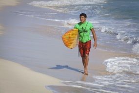 surfer walking on a sand beach