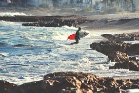 surfer going out of the water on ocean beach