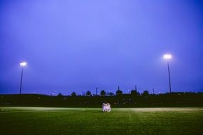 football team is hugging in the middle of a football field