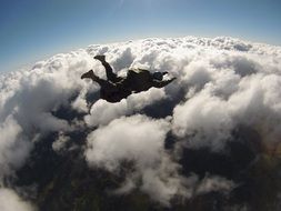 skydiver over clouds