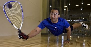 racquetball player hitting ball indoors