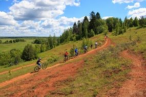 people riding bikes along the mountainside