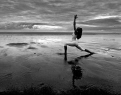 girl in white in yoga pose on the beach