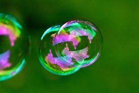 multicolored soap bubbles on a green background