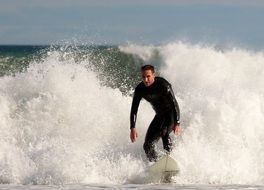 surfer on the surfboard among the waves