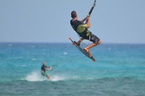 men are engaged in kitesurfing in the ocean