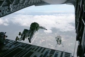skydivers jump from a helicopter