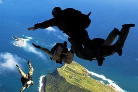 Paratroopers soar in the air above the ocean