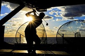 silhouette of a golfer during sunset