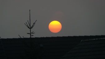 sunset, orange fireball at grey sky