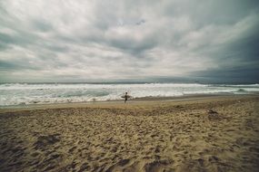 surfer with surfboard walking on beach