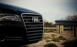 black audi, front of luxury sports car